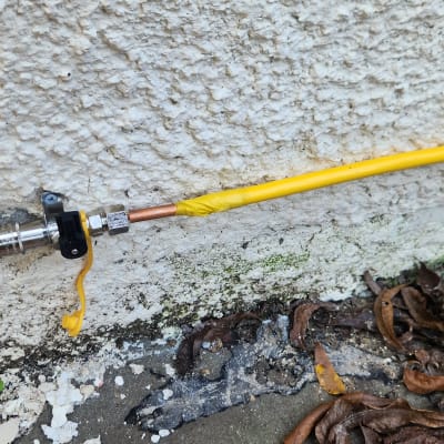 צינור גז צהוב מחובר לקיר עם שסתום מתכת