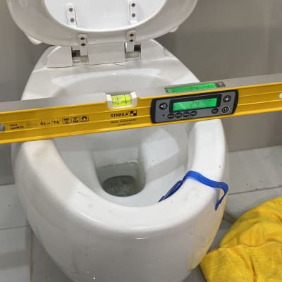 פלס דיגיטלי מונח על אסלה לבדיקת איזון