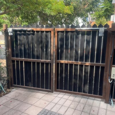 שער חשמלי חום עם לוחות עץ שחורים