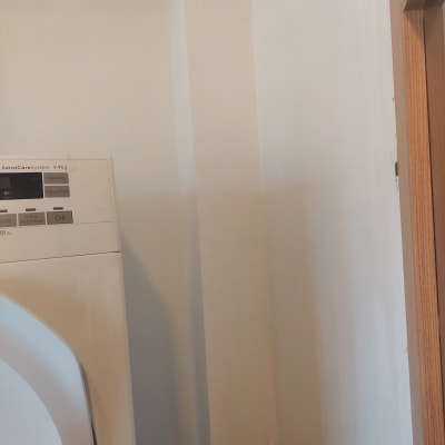 קיר צבוע עם מכונת כביסה וצינורות