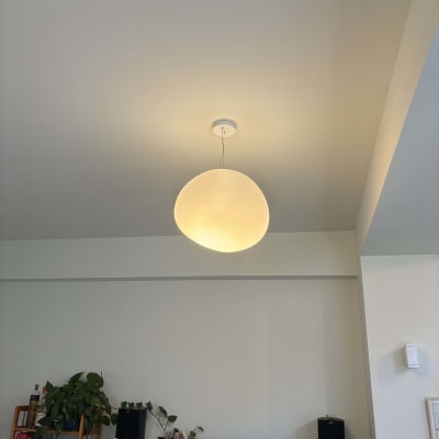 מנורה עגולה תלויה מהתקרה עם סולם עץ מתחתיה