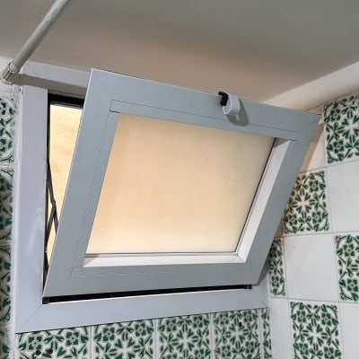 חלון אלומיניום פתוח עם מסגרת לבנה