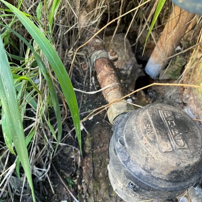מד מים ישן עם צינור חלוד ועשבים