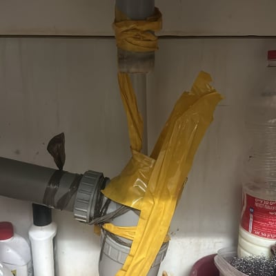 צינור מתחת לכיור עטוף בנייר דבק צהוב