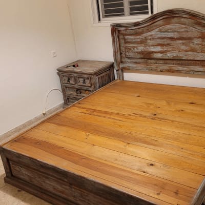 מיטה מעץ עם שידה בחדר ריק