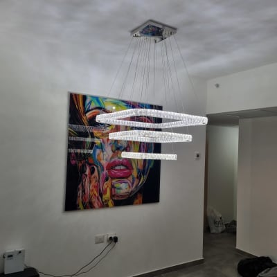 מנורת תקרה מעוצבת תלויה בחדר עם ציור קיר צבעוני