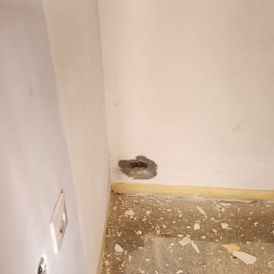 קיר עם חורים ורצפה עם שאריות צבע