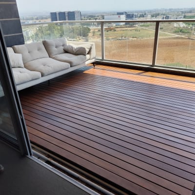 מרפסת עם רצפת עץ וספה לבנה