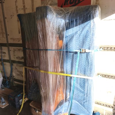 רהיטים עטופים ומאובטחים ברצועות בתוך משאית הובלה