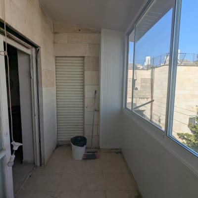 מרפסת עם חלונות אלומיניום ודלתות זכוכית