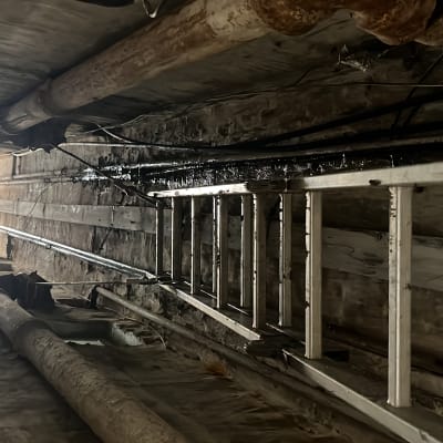 צינורות חלודים ותקרה עם סולם מתכת