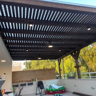 פרגולה מעץ עם תאורה מובנית בגינה