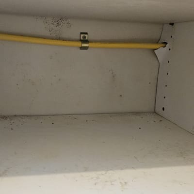 כבל צהוב מחובר לקיר בתוך ארון לבן