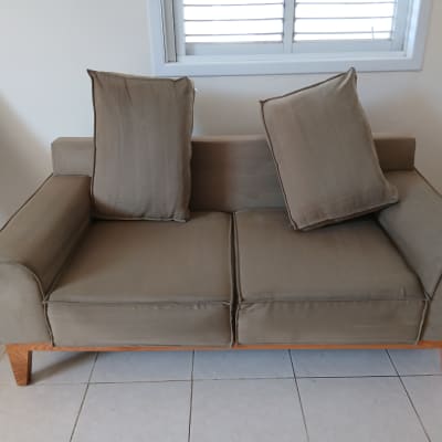 ספה חומה עם כריות על רצפת אריחים