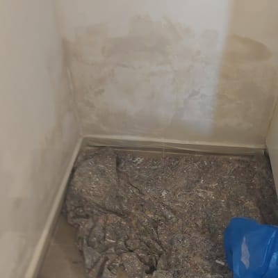 קיר עם סימני צבע ויריעות מגן על הרצפה