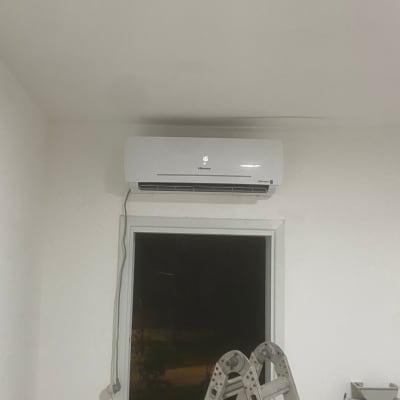 מזגן מותקן על קיר מעל חלון עם סולם לידו