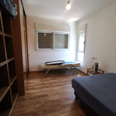 חדר עם מיטה, מדף פתוח, חלון ומנורה תלויה