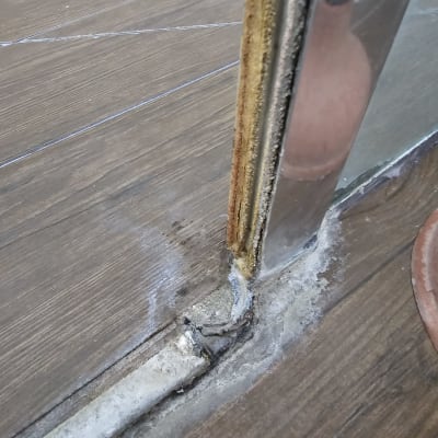 חיבור מתכת וזכוכית עם סימני חלודה במקלחת