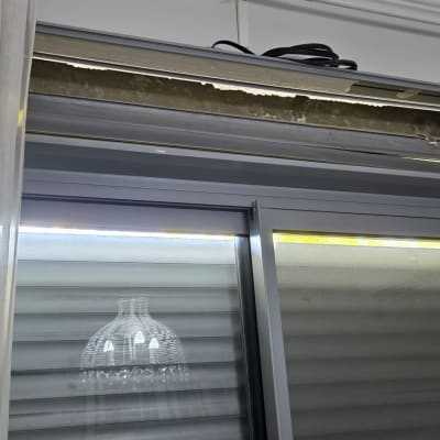 תריס גלילה פתוח עם וילונות לבנים