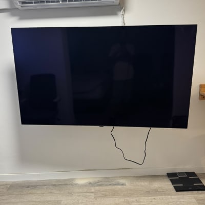 תליית טלוויזיה רחבה על קיר פנימי לבן