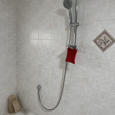 מקלחת עם ראש מקלחת חדש ומגבת אדומה