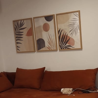 ספה חומה עם שלוש תמונות קיר דקורטיביות