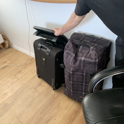 אדם מניח מחשב נייד על מזוודות בחדר