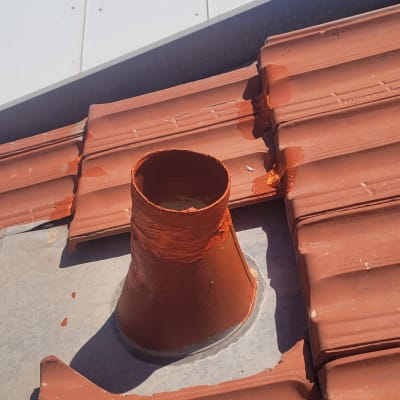 ארובה על גג רעפים אדומים עם איטום