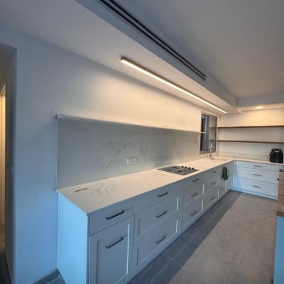 משטחי שיש במטבח מודרני עם ארונות לבנים