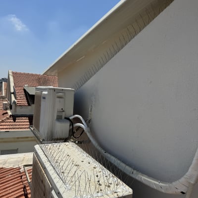 קוצים על גג למניעת ציפורים ליד מזגן
