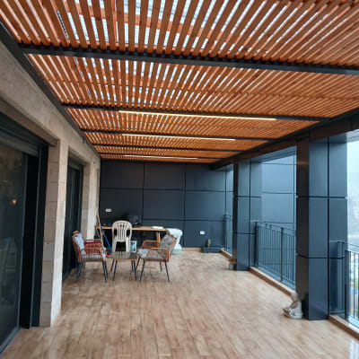 פרגולה מעץ על מרפסת עם רצפת עץ וכיסאות