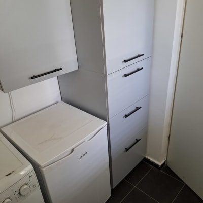 ארונות מטבח עם ידיות שחורות ומכונת כביסה