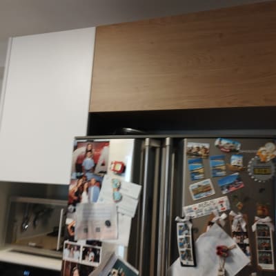 מטבח עם מקרר ומגנטים, ארונות עץ ולבן