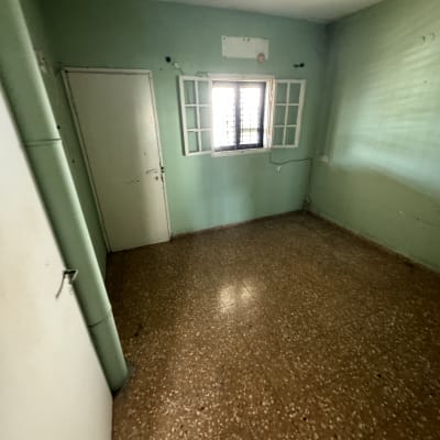 חדר ריק עם קירות ירוקים ורצפת טרצו