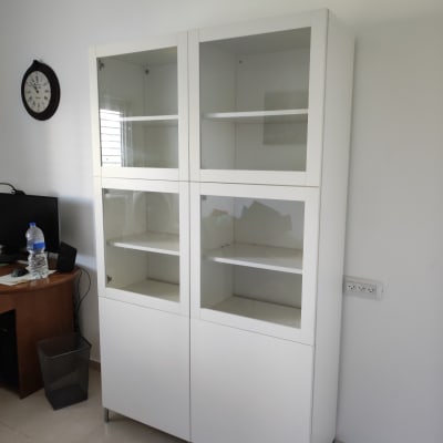 ארון לבן עם דלתות זכוכית ומדפים פנימיים