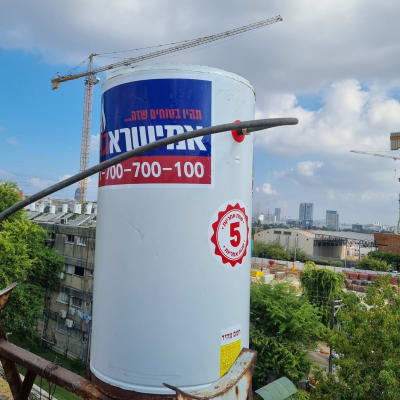 דוד שמש עם מדבקה אדומה וכחולה על גג