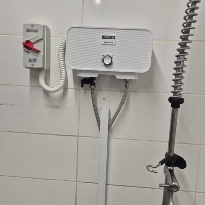 דוד חשמלי מותקן על קיר עם צינורות