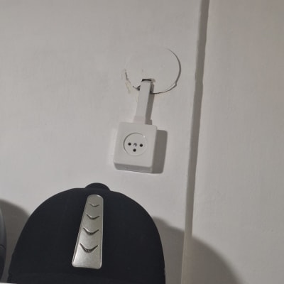שקע חשמלי על קיר לבן עם חוט חשמל
