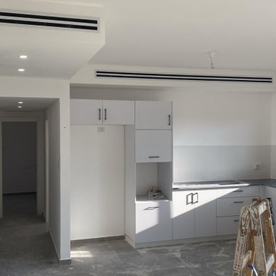 פתחי מיזוג אוויר בתקרה לבנה בחדר ריק