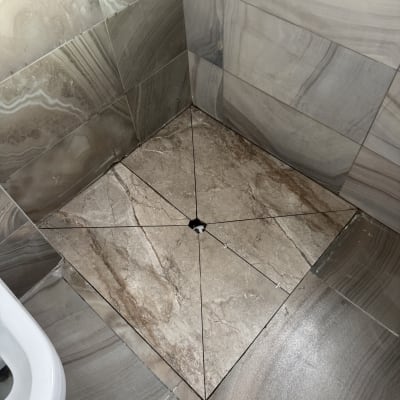 ריצוף חדש בחדר אמבטיה עם אריחים חומים