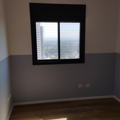 חלון אלומיניום עם מסגרת כהה בחדר ריק