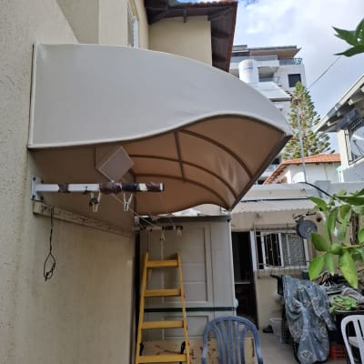 סוכך מותקן על קיר עם סולם וכיסא פלסטיק
