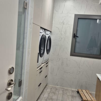 חדר כביסה עם מכונות כביסה וארונות מותקנים