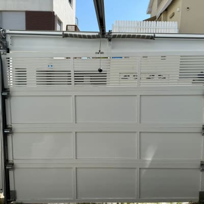 שער חשמלי לבן עם מנגנון פתיחה עליון