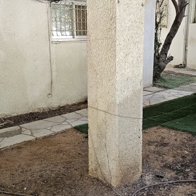 עמוד בטון עם סדק ליד מזגן חיצוני
