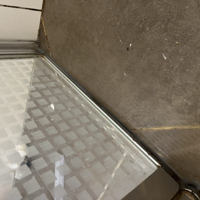 פינת מקלחון עם דלת זכוכית ודוגמת ריבועים