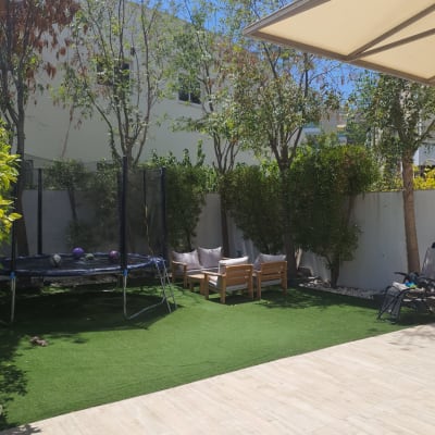 דשא סינתטי עם עצים מסביב בגינה פרטית