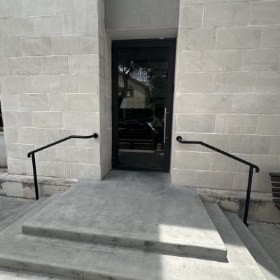 דלת זכוכית עם מסגרת מתכת ושני מעקות ברזל