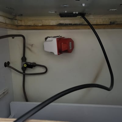 שקע חשמלי אדום עם כבל מחובר לקיר