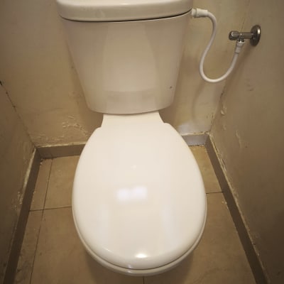 אסלה עם צינור מים מחובר לקיר